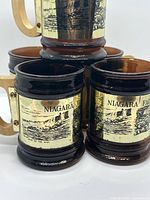 Front view showing gold Niagara Falls label and wood handles