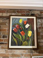 Full view of framed tulip painting on brick wall