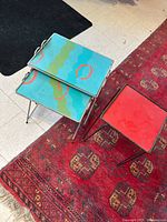 View of two nesting tables and red table on rug