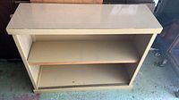 Full view of beige laminate cabinet showing open front, adjustable shelf, bottom track