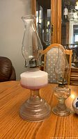 Large and small glass oil lamps on table