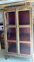Full frontal view of ornate freestanding cabinet showing double doors and interior shelves