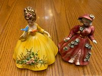 Front view of both porcelain figurines on wooden table
