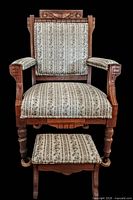 Front view of carved Eastlake armchair and footstool