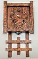 Full view of oak wall clock showing case, pendulum and lattice lower design
