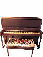 Full view upright piano with bench in front