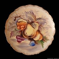 Full top view of the plate showing entire fruit design and scalloped gilt edge
