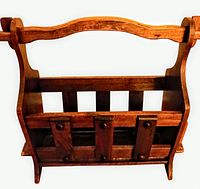 full view from above of solid wood magazine rack showing handle, side curves and slatted fronts