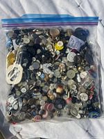 Large resealable plastic bag filled with an assortment of vintage buttons in multiple colors, sizes, and materials.