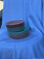 Stacked teal and brown plates shown side by side on blue blanket, highlighting color and shape variations
