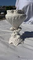 Front-right angle photo of white porcelain Spode vase with cherubs and floral relief patterns.