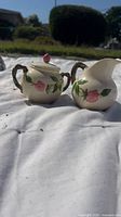 Photo of Franciscan Rose sugar bowl and creamer on white cloth outdoors