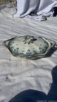 Photo of the vintage ceramic soup tureen with lid on a white cloth, showing detailed blue floral patterns and the ornate lid handle.