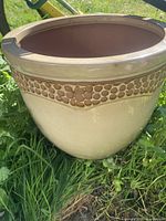 Side view of ceramic flower pot planter showing beige glaze with decorative honeycomb band and slightly flared rim.