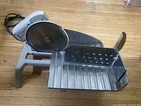Top-side view of Rival electric food slicer showing blade, carriage, and pusher
