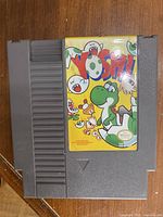 Gray Nintendo Entertainment System cartridge with colorful Yoshi label featuring Yoshi and ghosts on yellow background in good condition.