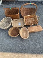 Photo showing all nine baskets arranged on the ground, various shapes and sizes, different woven styles and tones.