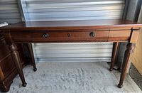 Front view of wooden console table showing two drawer knobs and keyhole.