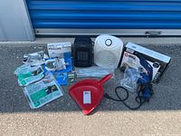 Lot overview photo showing all items including Philips travel iron, drill in box, two small heaters, window seal packs, dustpan, and hardware parts.