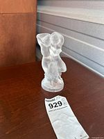 Full view of frosted glass figurine showing two nude figures embracing on a round base with Lalique marking.