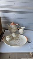 Photo showing the full Royal Doulton Meadow Glow pottery set including teapot, creamer, salt and pepper shakers, and platter on white surface