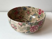 Angled front view of the bowl showing floral pattern and overall condition with visible crackle crazing.