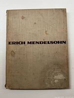 Front cover of the book showing tan cloth binding with title 'Erich Mendelsohn' in dark brown text. Moderate wear and some stains visible.