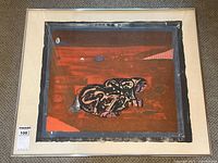 Full view of framed abstract elephant print on red textured background.