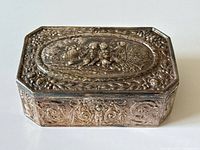 Three-quarter front view of box showing overall shape and top and side repoussé details