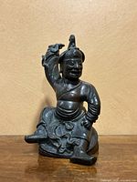 Front view of seated bronze Chinese figure on wood stand
