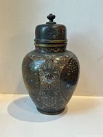 Front view of the antique cloisonné jar showing floral and butterfly enamel design and lid with finial