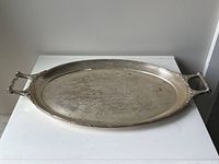 Full view of oval silver tray with handles on each end