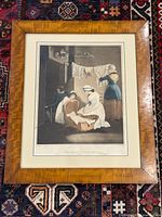 Photo of framed lithograph on a patterned rug, showing entire frame and print.
