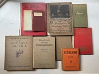 Photo of eight antique German books focused on art and culture, showing a variety of cover designs and sizes.