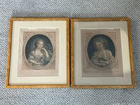 Pair of framed antique hand coloured engravings of young women placed side by side on carpet