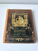 Front cover of the antique book showing embossed gold detailing and the title about Rome and the Vatican