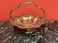 Front and overall view of the ornate silver plated basket showing detailed design on sides and handle