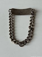 Full view of sterling silver ID bracelet showing curb chain and engraved ID plate.