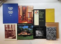 Full spread of ten architecture books arranged on a white surface, showing covers with various architectural themes and styles including Frank Lloyd Wright and Canadian architecture.