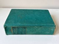 Book closed, front cover down showing green cloth boards and spine imprint