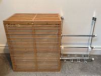 Full view of the double bamboo laundry basket with attached wall-mounted metal rack.