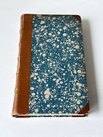 Front cover showing half leather binding and blue marbled pattern with white spots.