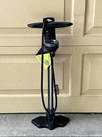 Full view of Raleigh bicycle floor pump with black plastic handle, base, and pressure gauge attached on metal shaft.
