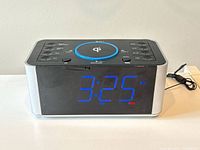 Front view of digital alarm clock radio showing blue LED time display and silver sides.
