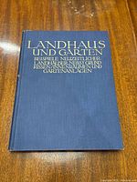 Front cover of the book 'Landhaus und Garten' showing title in gold lettering on dark blue hard cover.