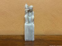 Front view of the stone seal showing the seated elder figure and the rectangular base