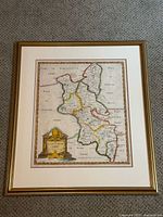 Full view of framed hand-coloured antique map of Buckinghamshire by Robert Morden on a beige carpet background.