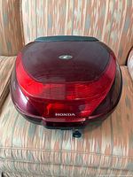 Front view of the red Honda scooter trunk with integrated rear light and Honda logo