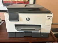 Front view of HP OfficeJet Pro 9025 showing overall look with paper trays and touchscreen.