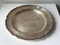 Full top view of round silver tray showing laurel‐edge border and patinated surface